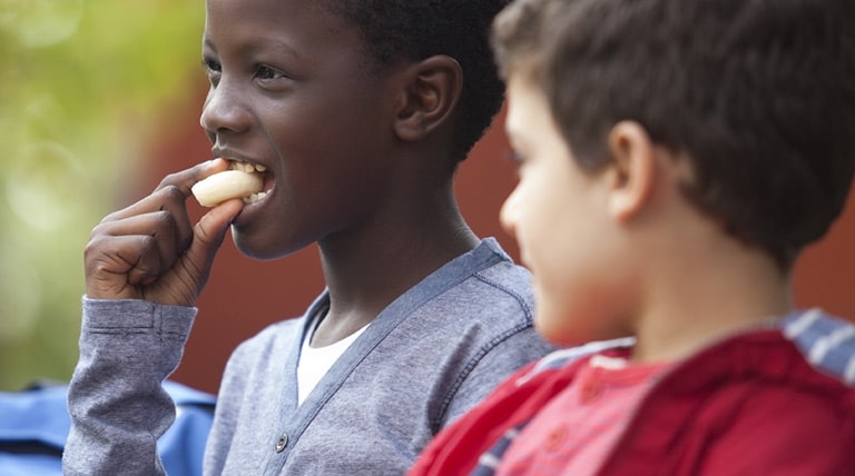 Boy eating a portion of Babybel